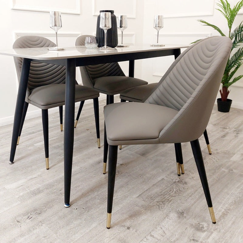 The Titus Dining Table is a real statement dining set, boasting a 140cm tabletop marble effect veneer, sleek black legs, leather chairs, full luxury dining set