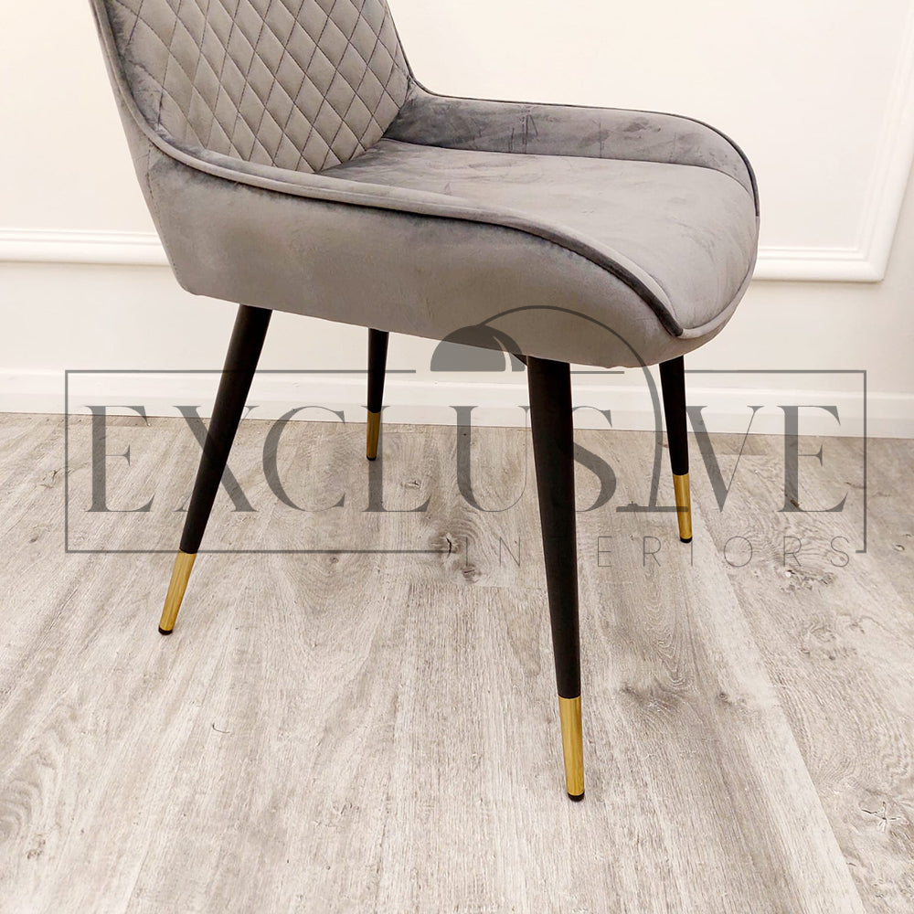 Beautiful Luna Velvet Dining Chair Scandinavian style cross stitch back detail gold tipped black legs. Comfortable luxury chairs, opulent dining chairs styles in grey